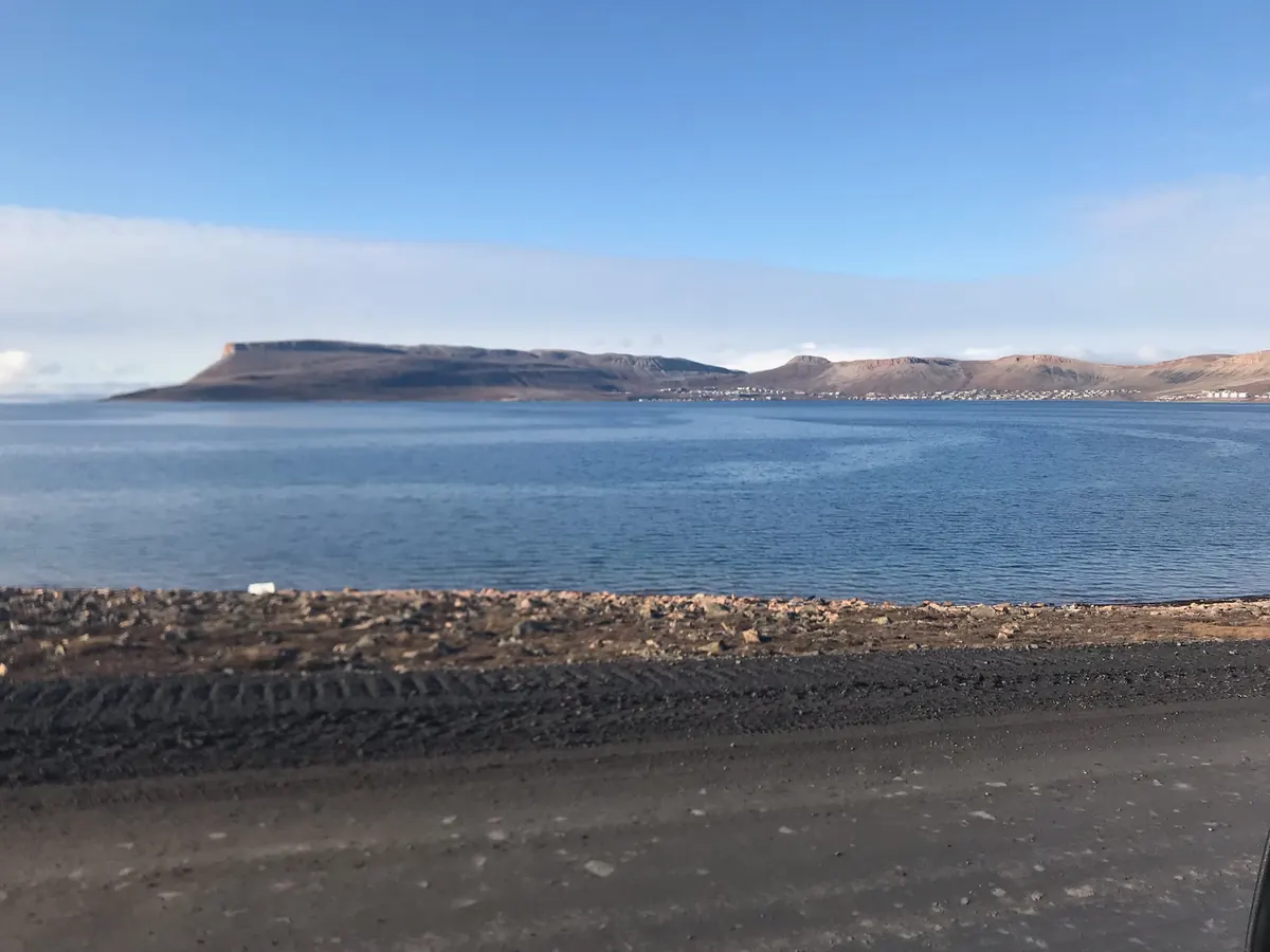 A calm northern bay with flat-topped hills on the far shore